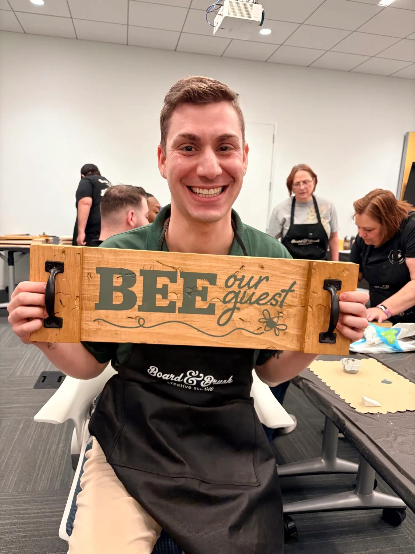 Andrew Mastracchio bei einem Team-Event mit einem bemalten Holzschild